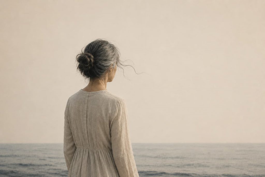 Ilustración de una mujer de espaldas frente al mar que simboliza el duelo, la memoria y la reconstrucción personal.