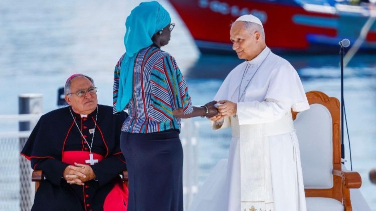 El papa León XIV estrecha la mano de una voluntaria durante el testimonio de una víctima de trata en Arguineguín